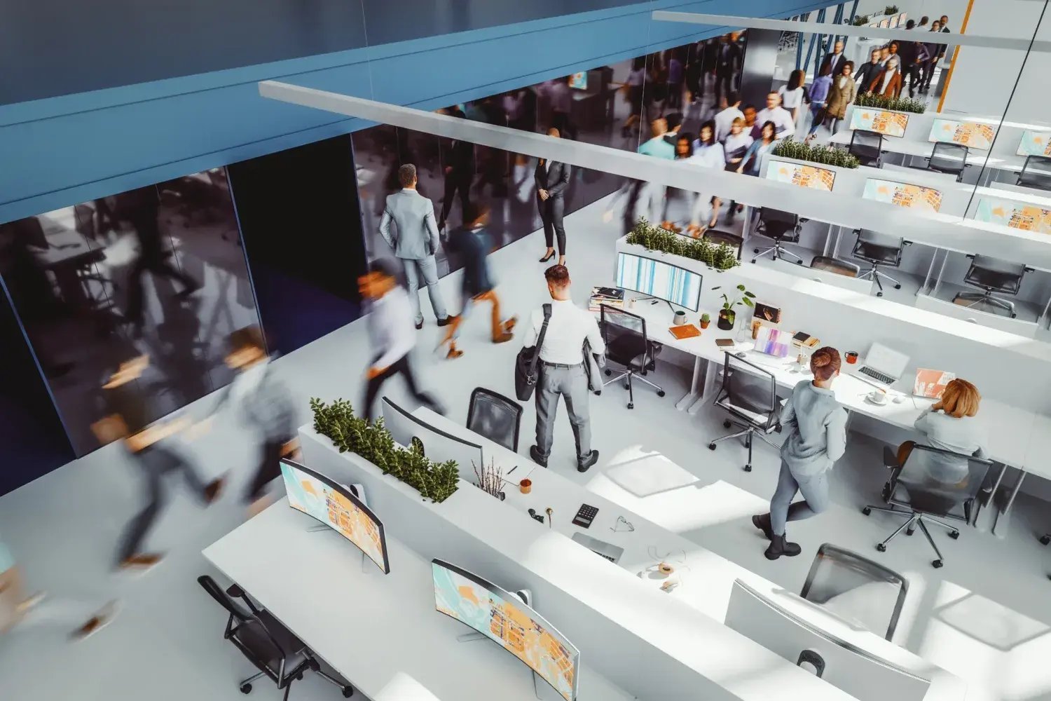 Busy office environment with people in motion. 3D generated image. People in motion/camera facing are generic human figures not based on any real person. All monitor/laptop images are my own and are just 3D renders as well.